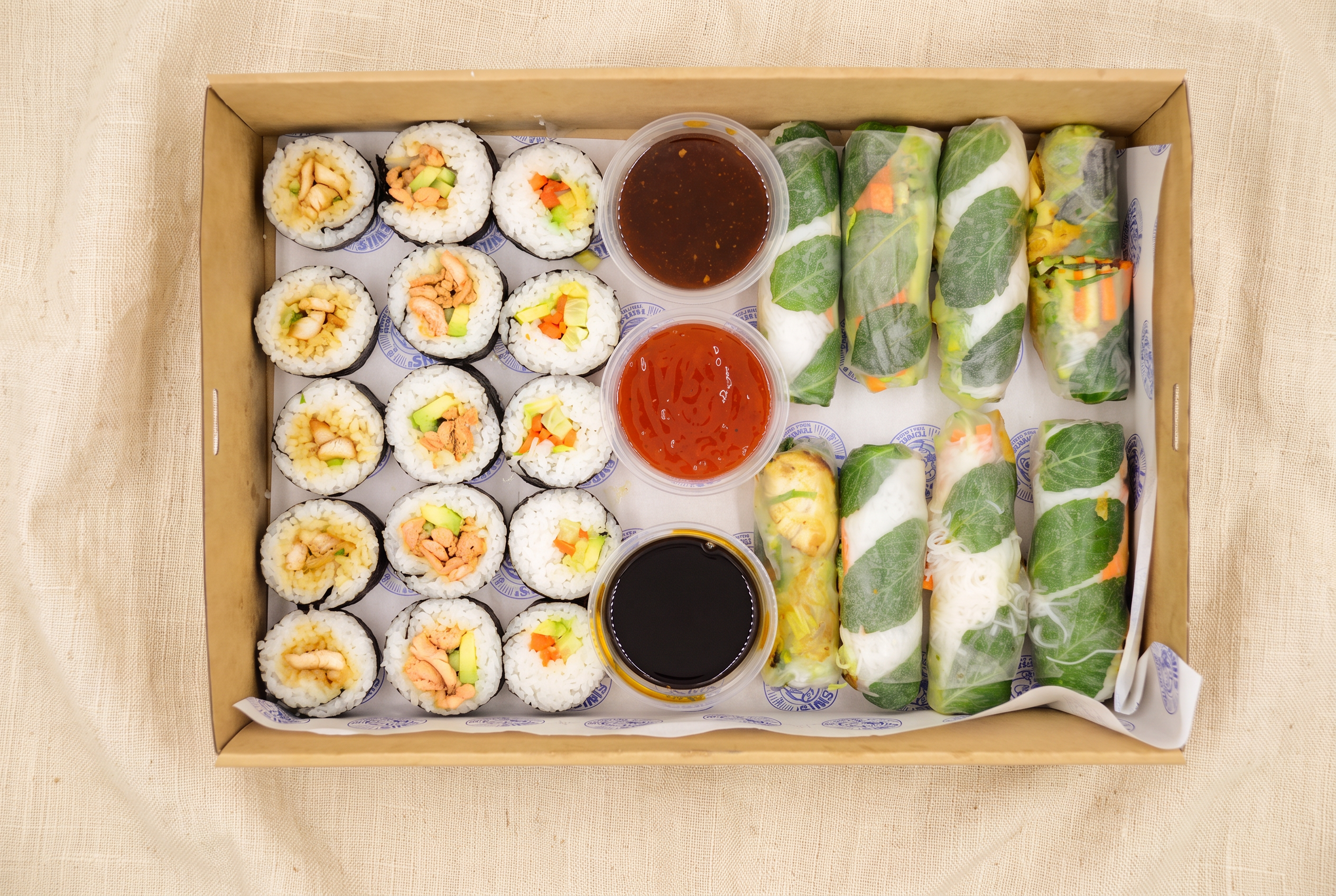 Mixed Rice Paper Rolls & Sushi - Beef, Chicken, Veg catering box on linen